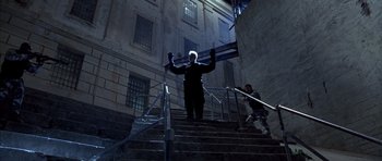 Movie still from “The Rock” (1996), directed by Michael Bay – A man standing on some steps in the dark; Wide shot, Low angle
