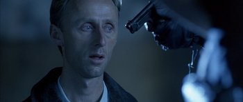 Movie still from “The Rock” (1996), directed by Michael Bay – A man with a gun pointed at his face; Close Up shot, Over the shoulder angle