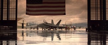 Movie still from “The Rock” (1996), directed by Michael Bay – A group of people standing next to an american flag; Extreme Wide shot, Low angle