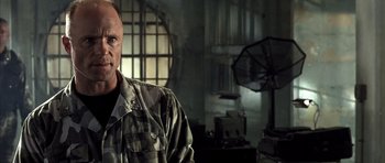 Movie still from “The Rock” (1996), directed by Michael Bay – A man in a military uniform in a room; Close Up shot, Low angle