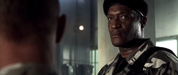 Movie still from “The Rock” (1996), directed by Michael Bay – A person wearing a hat looking at the camera; Close Up shot, Low angle