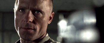 Movie still from “The Rock” (1996), directed by Michael Bay – A man's face with a light shining on it; Close Up shot, Low angle