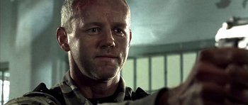 Movie still from “The Rock” (1996), directed by Michael Bay – A person with a gun in a room; Close Up shot, Over the shoulder angle