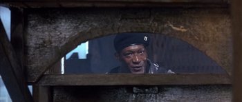 Movie still from “The Rock” (1996), directed by Michael Bay – A man looking into a mirror in a building; Close Up shot, Low angle