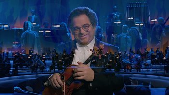 Movie still from “Fantasia 2000” (1999), directed by Eric Goldberg – A man holding a violin in front of an orchestra; Medium shot, Low angle