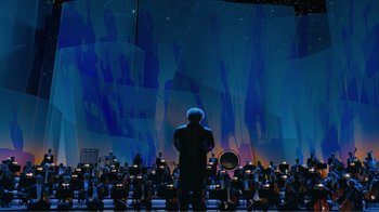 Movie still from “Fantasia 2000” (1999), directed by Eric Goldberg – A man standing in front of an orchestra on a stage; Extreme Wide shot, Low angle