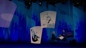 Movie still from “Fantasia 2000” (1999), directed by Eric Goldberg – Two men sitting in front of a projection screen; Wide shot, Low angle
