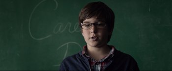 Movie still from “Fantastic Four” (2015), directed by Josh Trank – A young boy wearing glasses standing in front of a chalkboard; Close Up shot, Over the shoulder angle