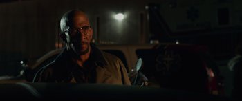 Movie still from “Fantastic Four” (2015), directed by Josh Trank – A man with glasses is sitting in the back of a car; Close Up shot, Over the shoulder angle