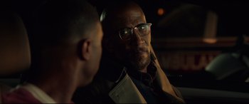 Movie still from “Fantastic Four” (2015), directed by Josh Trank – A man with glasses talking to another man in a dark room; Close Up shot, Over the shoulder angle