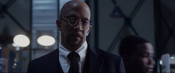 Movie still from “Fantastic Four” (2015), directed by Josh Trank – A bald man wearing a suit and tie; Close Up shot, Low angle
