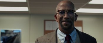 Movie still from “Fantastic Four” (2015), directed by Josh Trank – A bald man wearing a suit and glasses; Close Up shot, Low angle