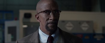 Movie still from “Fantastic Four” (2015), directed by Josh Trank – A bald man wearing glasses and a suit; Close Up shot, Over the shoulder angle