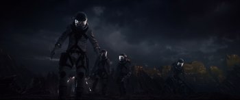 Movie still from “Fantastic Four” (2015), directed by Josh Trank – A group of people wearing helmets walking in the dark under a cloudy sky; Wide shot, Low angle