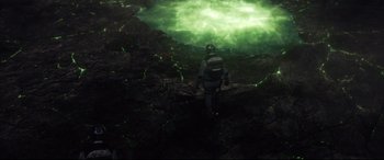 Movie still from “Fantastic Four” (2015), directed by Josh Trank – A person in a space suit is standing in front of a green light; Extreme Wide shot, Overhead angle