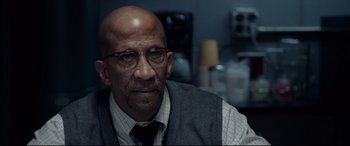 Movie still from “Fantastic Four” (2015), directed by Josh Trank – A bald man wearing glasses and a tie; Close Up shot, Over the shoulder angle