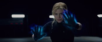 Movie still from “Fantastic Four” (2015), directed by Josh Trank – A woman with blonde long hair is holding her hands up in the dark; Close Up shot, Over the shoulder angle