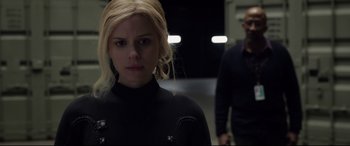 Movie still from “Fantastic Four” (2015), directed by Josh Trank – A woman in a black jacket standing next to a man in glasses; Close Up shot, Over the shoulder angle