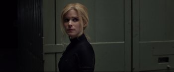 Movie still from “Fantastic Four” (2015), directed by Josh Trank – A woman with blonde hair wearing a black top; Close Up shot, Over the shoulder angle