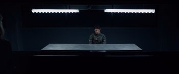 Movie still from “Fantastic Four” (2015), directed by Josh Trank – A man sitting in front of a mirror in front of a wall; Wide shot, Low angle