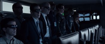 Movie still from “Fantastic Four” (2015), directed by Josh Trank – A group of men in suit and tie wearing sunglasses; Medium shot, Over the shoulder angle