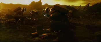 Movie still from “Fantastic Four” (2015), directed by Josh Trank – A man in a helmet kneeling down next to an open case; Wide shot, High angle