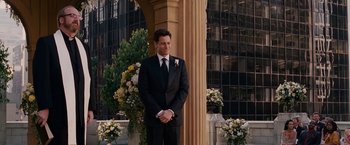 Movie still from “Fantastic Four: Rise of the Silver Surfer” (2007), directed by Tim Story – A man in a tuxedo standing in front of a building; Wide shot, Over the shoulder angle