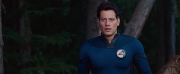 Movie still from “Fantastic Four: Rise of the Silver Surfer” (2007), directed by Tim Story – A man in a blue and black outfit standing in front of trees; Close Up shot, Low angle