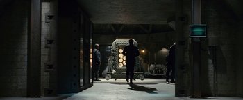 Movie still from “Fantastic Four: Rise of the Silver Surfer” (2007), directed by Tim Story – A group of people standing around a machine in a room; Wide shot, Low angle