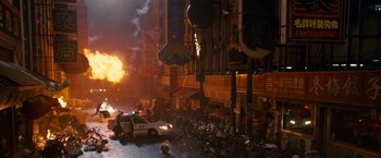 Movie still from “Fantastic Four: Rise of the Silver Surfer” (2007), directed by Tim Story – A police car driving down a street next to buildings; Extreme Wide shot, High angle