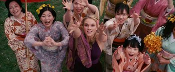 Movie still from “Fantastic Four: Rise of the Silver Surfer” (2007), directed by Tim Story – A group of people standing in the grass with their hands in the air; Medium shot, Overhead angle