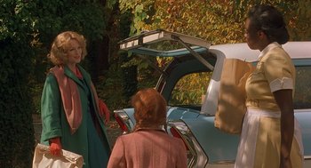 Movie still from “Far from Heaven” (2002), directed by Todd Haynes – Two women standing in front of a blue car; Medium shot, Over the shoulder angle