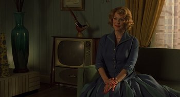 Movie still from “Far from Heaven” (2002), directed by Todd Haynes – A woman sitting in front of an old fashioned tv; Medium shot, Over the shoulder angle