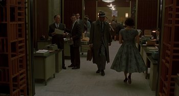 Movie still from “Far from Heaven” (2002), directed by Todd Haynes – A group of men and a woman walking down a hall way; Wide shot, High angle
