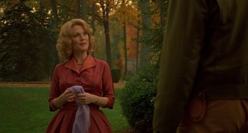 Movie still from “Far from Heaven” (2002), directed by Todd Haynes – A woman in a red dress holding a purple scarf; Medium shot, Over the shoulder angle