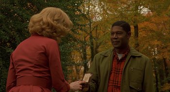 Movie still from “Far from Heaven” (2002), directed by Todd Haynes – A man and a woman are holding up a medal; Medium shot, Over the shoulder angle