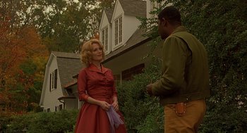 Movie still from “Far from Heaven” (2002), directed by Todd Haynes – A woman in a red dress talking to a man in a green shirt; Medium shot, Low angle