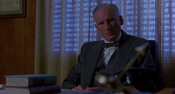 Movie still from “Far from Heaven” (2002), directed by Todd Haynes – A man sitting at a table in front of a window; Close Up shot, Low angle