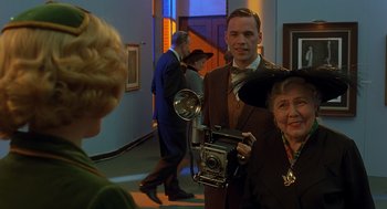 Movie still from “Far from Heaven” (2002), directed by Todd Haynes – A man holding a camera in front of two women; Medium shot, Over the shoulder angle