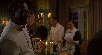 Movie still from “Far from Heaven” (2002), directed by Todd Haynes – A group of people standing around a table with candles; Medium shot, Over the shoulder angle