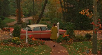 Movie still from “Far from Heaven” (2002), directed by Todd Haynes – A woman walking down a path towards a red car; Extreme Wide shot, High angle