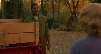 Movie still from “Far from Heaven” (2002), directed by Todd Haynes – A man standing in front of a wooden bench; Medium shot, Over the shoulder angle