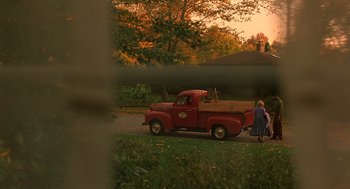 Movie still from “Far from Heaven” (2002), directed by Todd Haynes – An old red pick - up truck parked on the side of the road; Wide shot, High angle