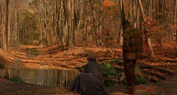 Movie still from “Far from Heaven” (2002), directed by Todd Haynes – A man and a woman sitting on the side of a river; Extreme Wide shot, High angle