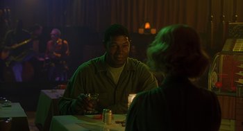 Movie still from “Far from Heaven” (2002), directed by Todd Haynes – A man sitting at a table with a glass of wine; Medium shot, Over the shoulder angle