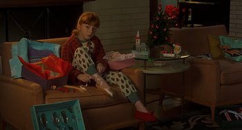 Movie still from “Far from Heaven” (2002), directed by Todd Haynes – A girl sitting on a couch in front of a christmas tree; Medium shot, High angle