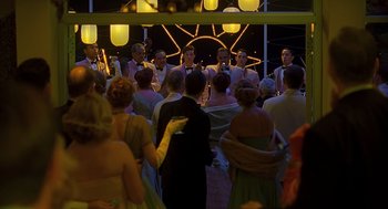 Movie still from “Far from Heaven” (2002), directed by Todd Haynes – A group of people standing in front of a stage; Wide shot, High angle