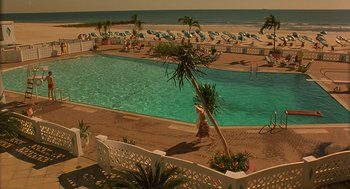 A person walking by a pool near the beach
