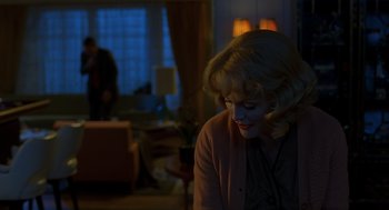 A woman sitting in front of a window in a living room