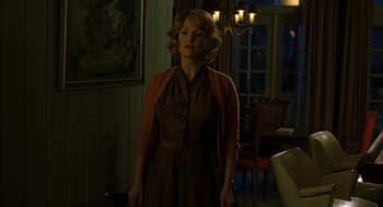 Movie still from “Far from Heaven” (2002), directed by Todd Haynes – A woman standing in a living room wearing a brown dress; Medium shot, Low angle